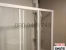 Compact bathroom with glass shower enclosure and wall-mounted water heater