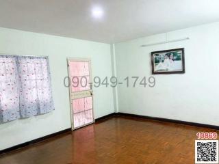 Spacious bedroom with hardwood floors, natural light, and a pink door