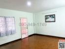 Spacious bedroom with hardwood floors, natural light, and a pink door