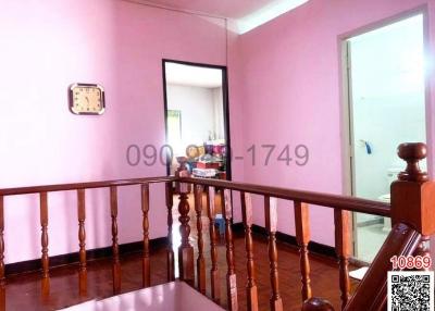 Bright hallway with wooden parquet flooring and pink walls
