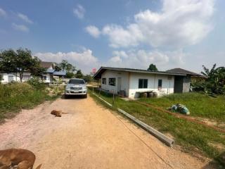 Simple single-story houses along a dirt road with a clear sky