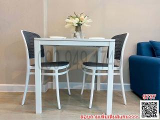 Modern dining area with a white table and chairs set against a minimalist decor