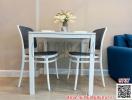 Modern dining area with a white table and chairs set against a minimalist decor