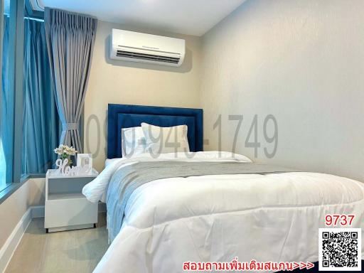 Modern bedroom interior with a large bed, blue headboard, and air conditioner