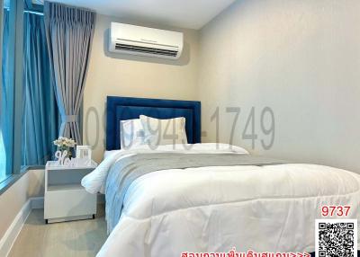 Modern bedroom interior with a large bed, blue headboard, and air conditioner