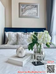 Elegant modern bedroom with a neatly made bed, decorative pillows, and a framed artwork