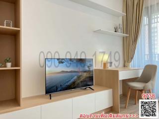 Modern living room with a large screen TV and view of the ocean