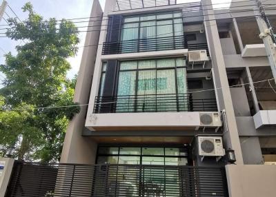 Modern multi-story residential building with balcony and security fence
