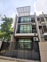 Modern multi-story residential building with balcony and security fence