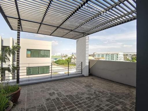 Spacious balcony with a pergola and urban view