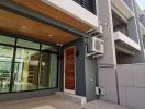 Contemporary two-story building exterior with glass facade and wooden door entry