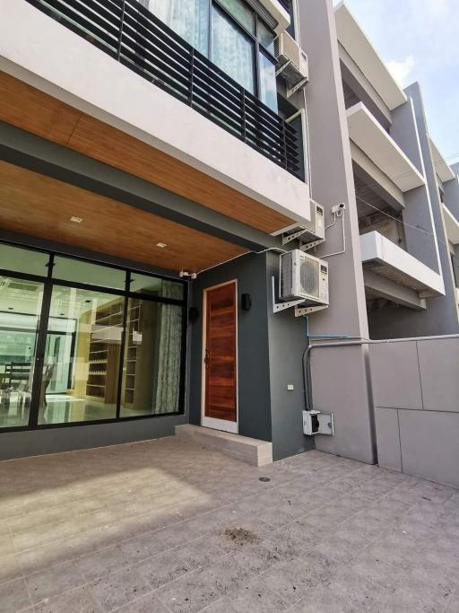 Contemporary two-story building exterior with glass facade and wooden door entry