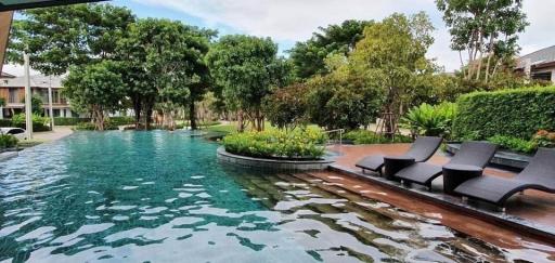 Luxurious outdoor swimming pool surrounded by lush greenery and comfortable lounge chairs