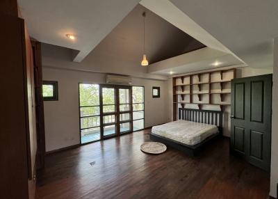 Spacious bedroom with hardwood floors and ample natural light