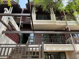 Exterior view of a multi-story residential building with balconies and lush greenery