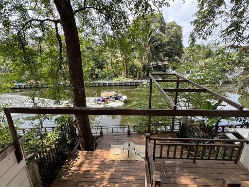 Spacious wooden deck overlooking a serene river with lush greenery