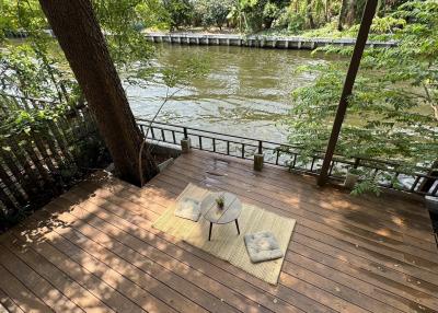Spacious outdoor deck by the river with comfortable seating and scenic view