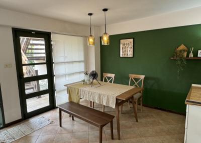 Cozy dining area with green accent wall and modern lighting