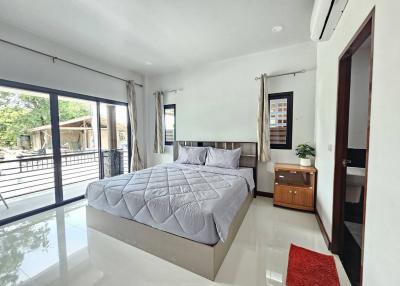 Spacious bedroom with modern design, large bed, and balcony access