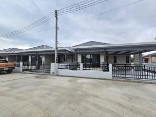 Front view of a modern single-story house with driveway and fencing