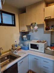 Compact kitchen with white cabinetry and essential appliances