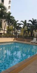 Swimming pool surrounded by palm trees in a residential complex