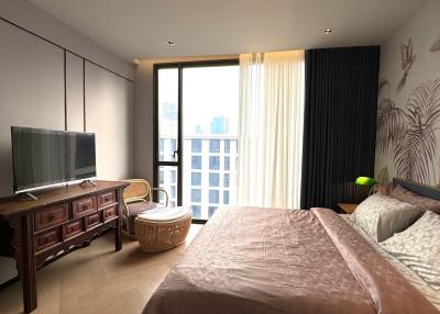 Cozy bedroom with a city view, featuring a large window and contemporary decor