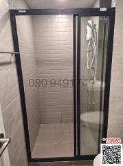 Modern bathroom with glass shower enclosure and grey tiles