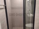 Modern bathroom with glass shower enclosure and grey tiles