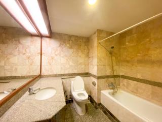 Spacious bathroom with marble tiles and modern fixtures