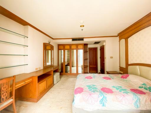 Spacious bedroom with built-in shelving and wood accents