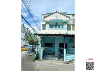 Exterior view of a two-story residential building with a blue facade and gated entrance