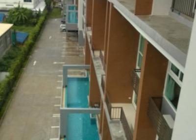 View of a residential building with swimming pool and parking