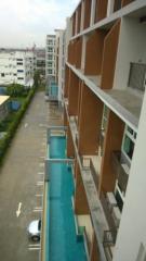 View of a residential building with swimming pool and parking
