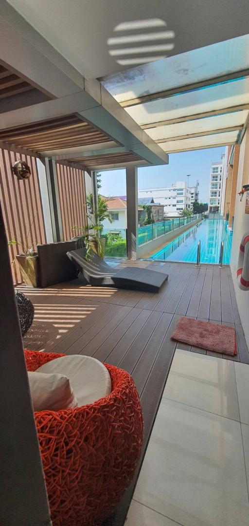 Modern outdoor patio with seating and swimming pool view in residential property