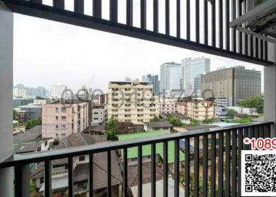 City view from a high-rise apartment balcony with metal railings