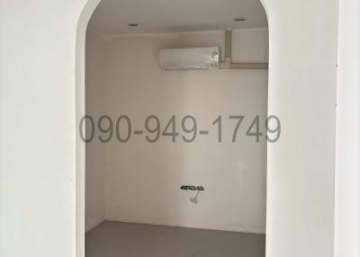 Empty white room with arched doorway and air conditioner