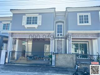 Modern two-story residential townhouse with a covered porch and balcony