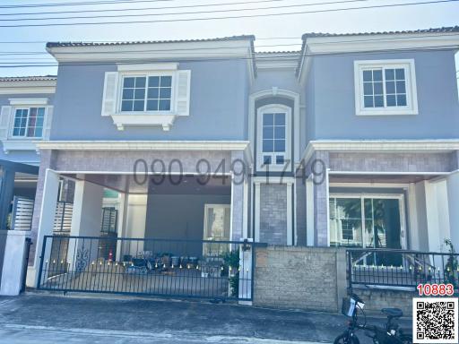 Modern two-story residential townhouse with a covered porch and balcony