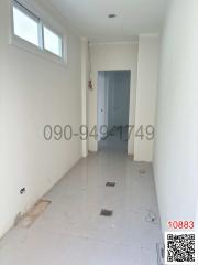 Unfurnished hallway in a new construction with high ceiling and tiled floor