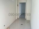 Unfurnished hallway in a new construction with high ceiling and tiled floor