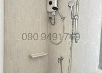 Compact bathroom with wall-mounted electric shower unit