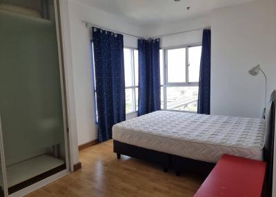 Cozy bedroom with a large window and blue curtains