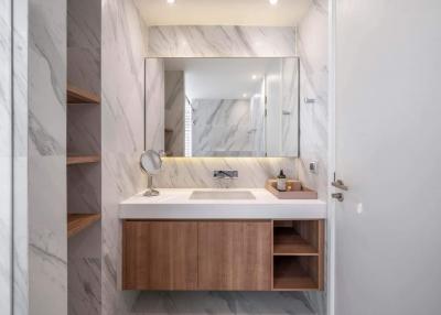 Modern bathroom with marble walls and wooden cabinetry