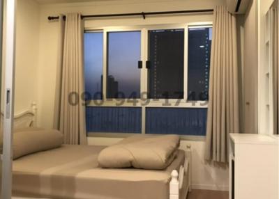 Cozy bedroom with large window and city view