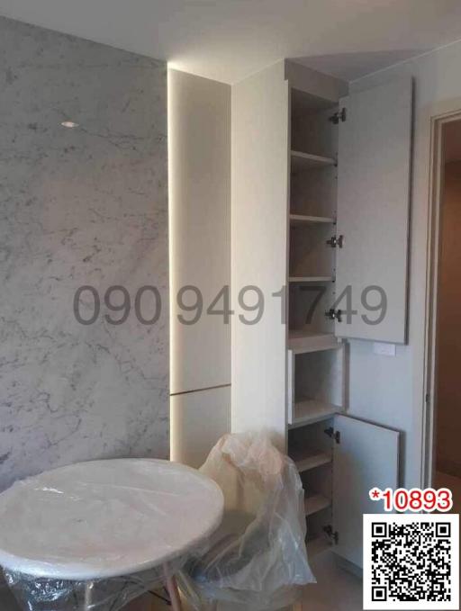 Modern bathroom with white marble walls, built-in shelving unit and round mirror