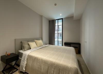 Spacious bedroom with large bed, ambient lighting and a view from the window.