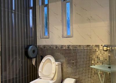 Modern bathroom with mosaic tiles and tall narrow windows