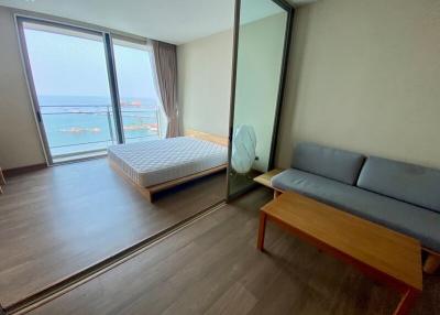 Bright and airy bedroom with a view of the water and a sitting area