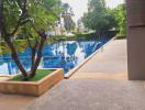 Outdoor area with swimming pool and lush greenery